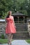 Gorgeous biracial woman poses wearing pink dress in garden