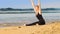 Gorgeous blond lady does stretching on gold sunlit beach