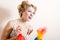 Gorgeous blond pretty funny girl young pinup woman having fun clean up, expressing fighting removing dust & looking at camera