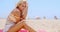 Gorgeous Blond Woman Sitting at the Beach Sand