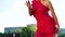 Gorgeous blonde woman in red dress dancing on street outside in slow motion