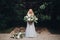 Gorgeous blondie bride in perfect wedding dress posing with big wedding boquet.