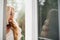 Gorgeous blondie bride walking at balcony and waiting for her groom.