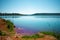 Gorgeous blue lake with sunlight glinting in it, surrounded by hills