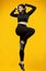 Gorgeous body positive Latin woman exercising on yellow background