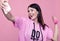 Gorgeous body positive Latin woman in a pink hoodie taking selfie