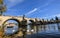 Gorgeous bottom-up view on ancient Charles Bridge, Vltava river embankment and swans, dramatic sky Prague, Czech Republic