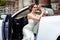 Gorgeous bride with fashion makeup and hairstyle near luxury wedding dress near white cabriolet car