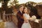 Gorgeous bride and lovely groom walking in golden autumn nature