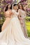 Gorgeous bride in luxurious wedding dress, posing with beautiful bridesmaids in elegant dresses