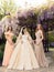 Gorgeous bride in luxurious wedding dress, posing with beautiful bridesmaids in elegant dresses