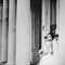 Gorgeous bride poses between pillars of the old building