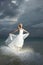 Gorgeous bride standing and posing under threatening clouds at s