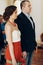 Gorgeous brunette bride holding hands with smiling groom at wedding registry office, cute stylish couple before wedding ceremony
