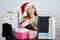 Gorgeous cheerful woman in red hat has preapred gifts on New Year