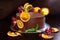 Gorgeous chocolate cake decorated with slices of baked orange and fresh pomegranate with a sprig of mint on a dark brown backgroun