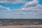 Gorgeous clouds in the blue sky above the stormy sea