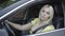 Gorgeous confident female driver turning on engine and driving away. Side view portrait of attractive blond Caucasian