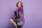 Gorgeous curly girl in stylish purple jacket dancing in front of bright wall. Indoor photo of stunning cute woman with