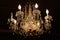 Gorgeous detail of old fashioned crystal chandelier lit in dark hallway of home