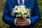 gorgeous elegant groom in blue suit holding stunning stylish bouquet