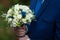 gorgeous elegant groom in blue suit holding stunning stylish bouquet
