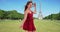 Gorgeous energetic woman in red dress dancing near Eiffel Tower in Paris