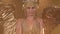 Gorgeous female actress dressed as the Greek goddess Artemis with wings. A slender woman in a gold suit and headdress