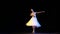 Gorgeous female dancer in ballet dress dancing solo part on dark stage in neon light. Concept of art, beauty, theater