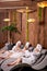 Gorgeous females in bathrobes and towels enjoying holidays in spa center, drinking champagne