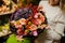 Gorgeous floral bouquet of roses and purple hydrangea in the woman`s hands