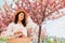 gorgeous gentle caucasian woman under blooming pink sakura tree