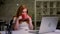 Gorgeous ginger caucasian businesswoman just finished her work on computer, sitting calmly, relaxed, drinking from red