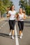 Gorgeous girls running on the blurred background. Sporty youth. Morning jogging concept.