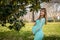 A Gorgeous Glowing Pregnant Woman Poses In An Outdoor Environment