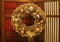 Gorgeous Gold Colored Christmas Wreath made from Gritter Ornamental Balls and Dry Pine Cones Decorating on the Door