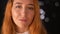 Gorgeous happy ginger caucasian woman is standing close up near camera , strengthening her hair and smiling nicely