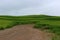 Gorgeous landscape with dirt path running through farmland in the rural countryside