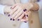 Gorgeous manicure, dark purple tender color nail polish, closeup photo. Female hands over simple background of casual clothes