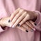 Gorgeous manicure, pastel tender pink color nail polish, closeup photo.