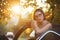 Gorgeous model wearing glasses, sitting in a convertible car with gold evening sunlight. Space for text