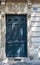 Gorgeous ornate stone fretwork above navy blue painted antique framed door of old building in Paris France.