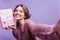 Gorgeous pale woman in knitted sweater making selfie with christmas present. Lovely short-haired lady holding birthday