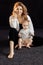 Gorgeous pretty woman posing in studio with adorable baby girl, smiling. Happy beautiful mother hugging little daughter