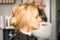 Gorgeous profile of caucasian beauty blonde woman with beautiful hairstyle over hair salon background.