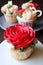 Gorgeous red rose frosting cupcake with another blurry cupcakes in background
