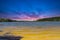 A gorgeous sandy beach on the banks of the rippling lake at sunset with powerful clouds at Dallas Landing Park