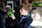 Gorgeous school kid boy feeding parrots in zoological garden. Child playing and feed trusting friendly birds in zoo and