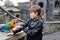 Gorgeous school kid boy feeding parrots in zoological garden. Child playing and feed trusting friendly birds in zoo and