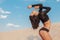 Gorgeous sexy woman dancing on the sand in the desert